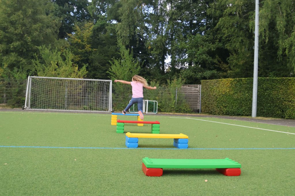 Kinder des TUS Sennelager spielen mit robusten XXL-Funblocks. Sie nutzen die großen Steckbausteine als Hürden und Parcours-Elemente beim Kindertraining und zeigen, wie vielseitig die stabilen Stapelsteine im Sport eingesetzt werden können.