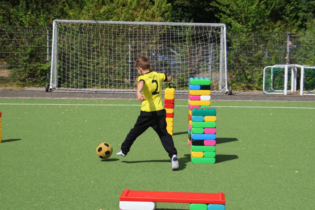 Kinder des TUS Sennelager spielen mit robusten XXL-Funblocks. Sie nutzen die großen Steckbausteine als Hürden und Parcours-Elemente beim Kindertraining und zeigen, wie vielseitig die stabilen Stapelsteine im Sport eingesetzt werden können.