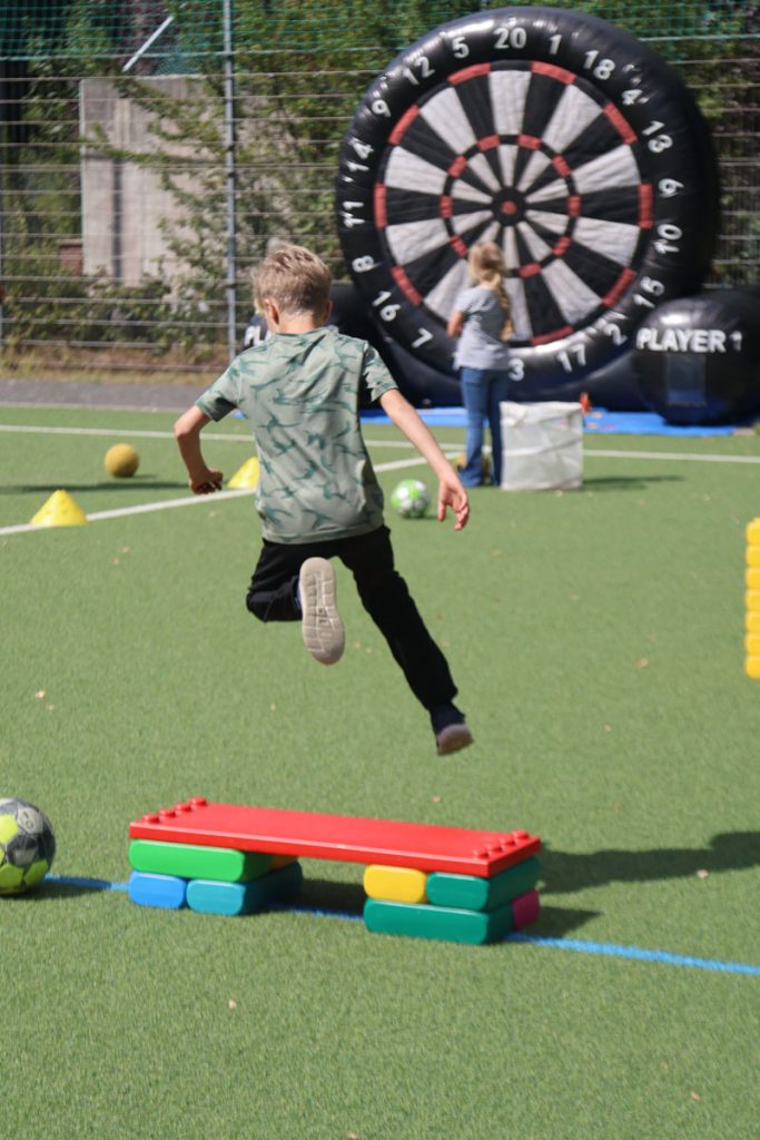 Kinder des TUS Sennelager spielen mit robusten XXL-Funblocks. Sie nutzen die großen Steckbausteine als Hürden und Parcours-Elemente beim Kindertraining und zeigen, wie vielseitig die stabilen Stapelsteine im Sport eingesetzt werden können.