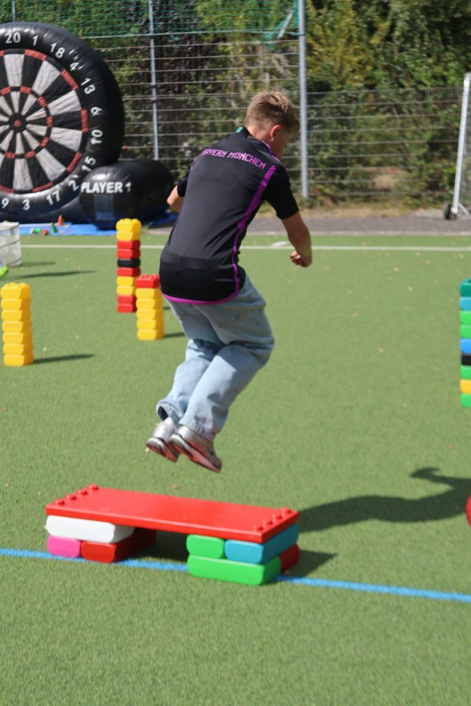 Kinder des TUS Sennelager spielen mit robusten XXL-Funblocks. Sie nutzen die großen Steckbausteine als Hürden und Parcours-Elemente beim Kindertraining und zeigen, wie vielseitig die stabilen Stapelsteine im Sport eingesetzt werden können.