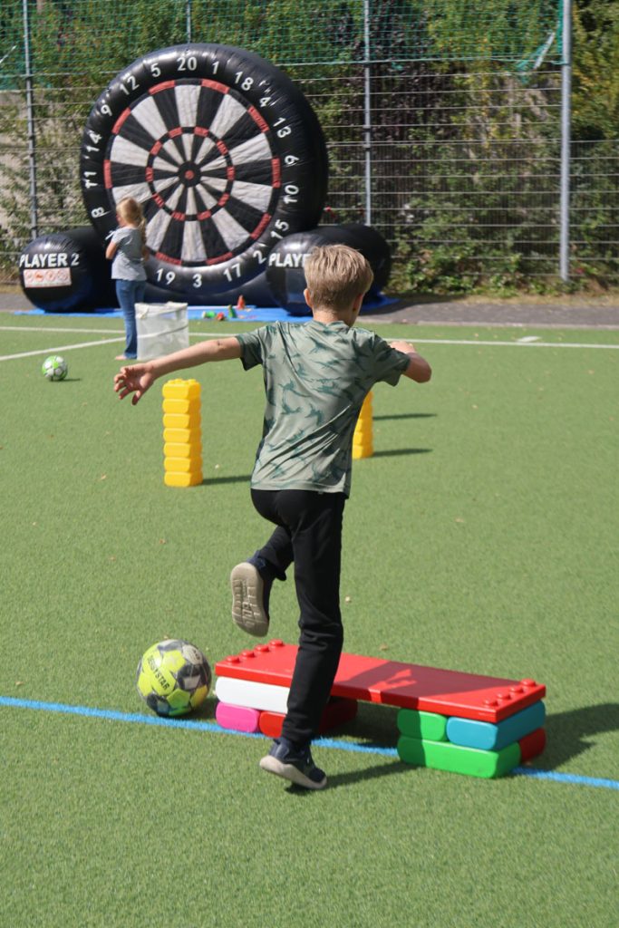 Kinder des TUS Sennelager spielen mit robusten XXL-Funblocks. Sie nutzen die großen Steckbausteine als Hürden und Parcours-Elemente beim Kindertraining und zeigen, wie vielseitig die stabilen Stapelsteine im Sport eingesetzt werden können.